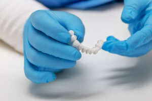 a periodontist holding a full mouth dental implant model.